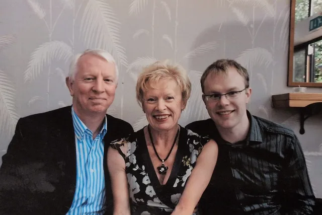 Iain, Pam and Euan sitting together at a table in a restaurant.